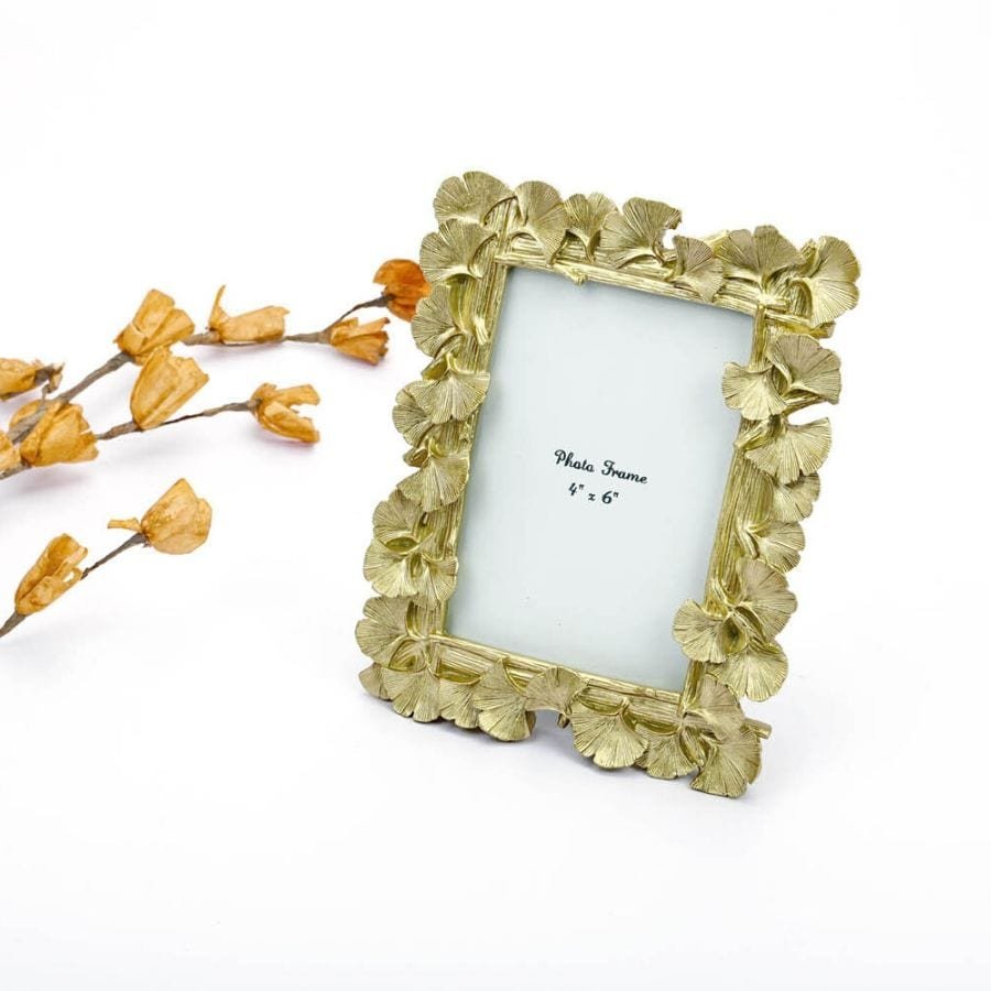 a table top Photo Frame with golden leaves on its borders