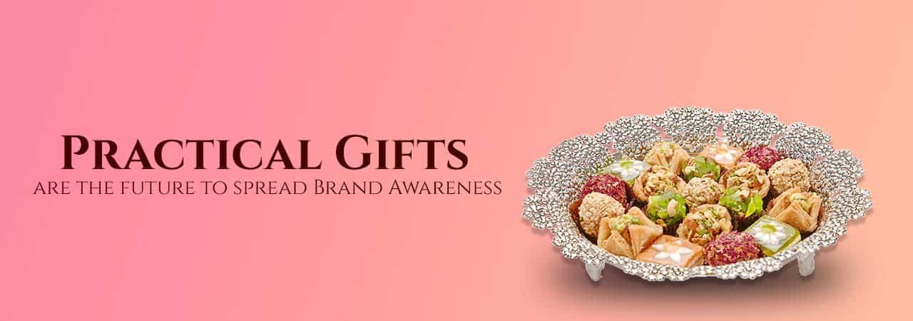a banner with a pink background showing a lovely silver tray along with sweets and a sentence saying - practical gifts are the future to spread brand awareness