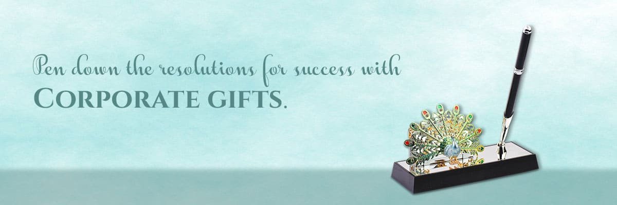 a banner with a blue background showing a picture of beautiful peacock pen stand & a sentence saying - pen down the resolutions for success with corporate gifts.