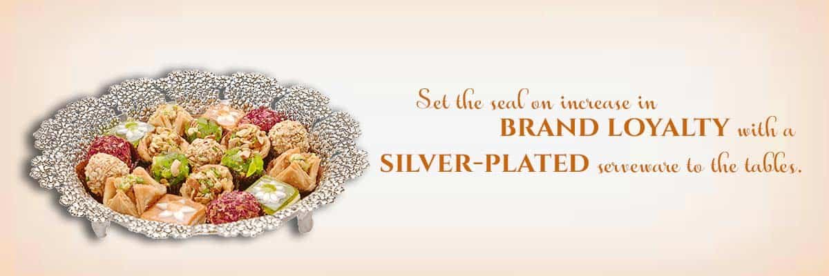 a banner with a peach background showing a unique silver tray with sweets & a sentence saying - set the seal on increase in brand loyalty with a silver-plated serveware to the tables