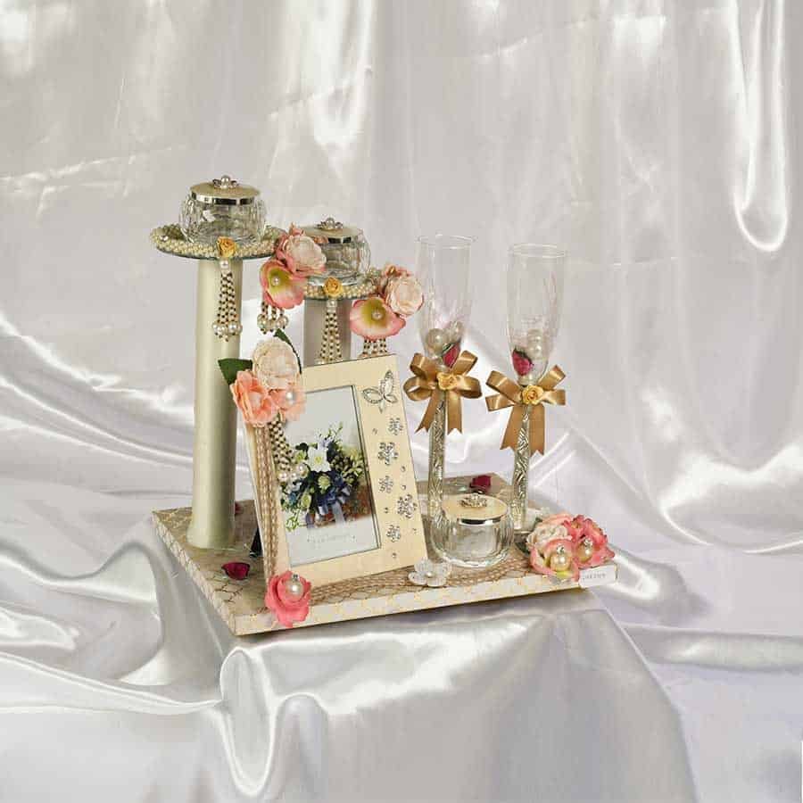 A Beautiful gift hamper consisting of Melange's exclusive Enameled Photo Frame of peach background, three crystal bowls of enameled lids & a set of two premium wine glasses