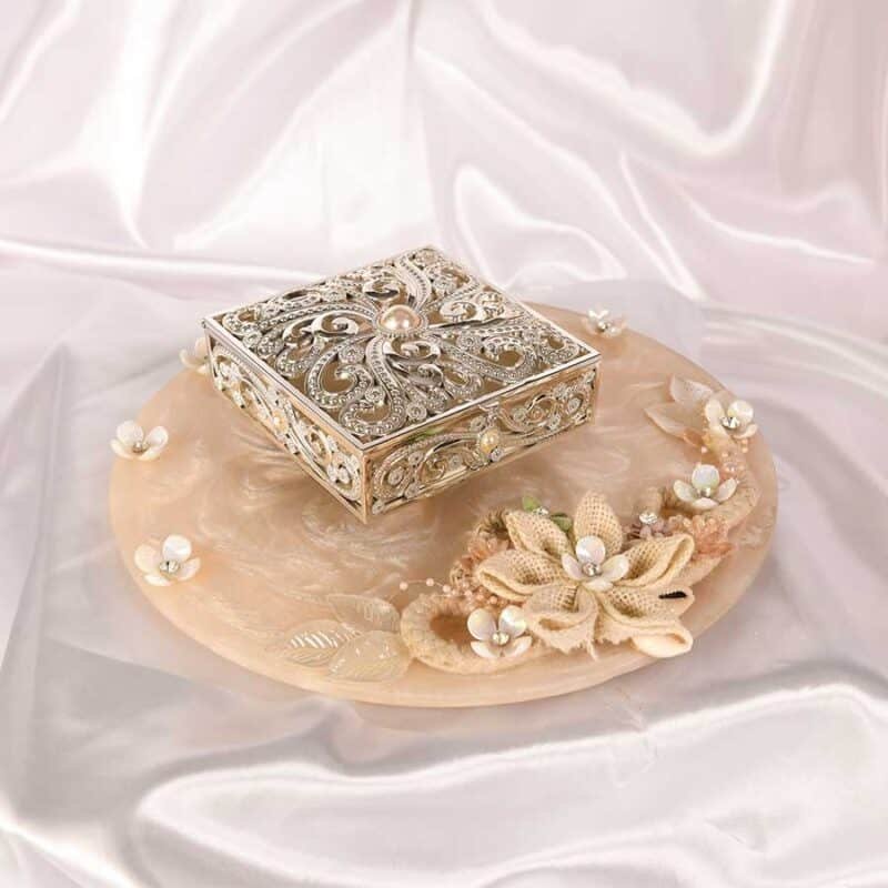 Cutwork Silver Box with pearls embedded on a beautiful peachy plate.
