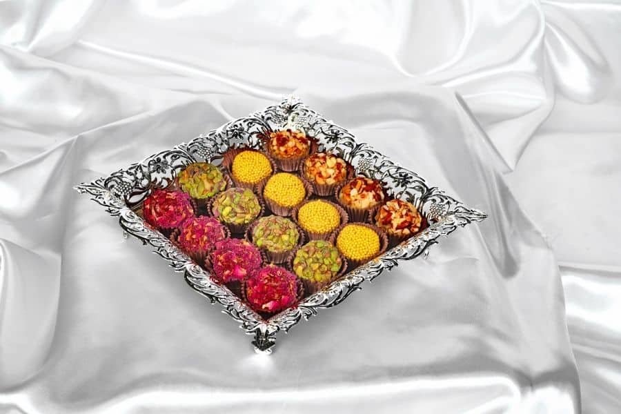 Square Cutwork Tray with sweets served in it.