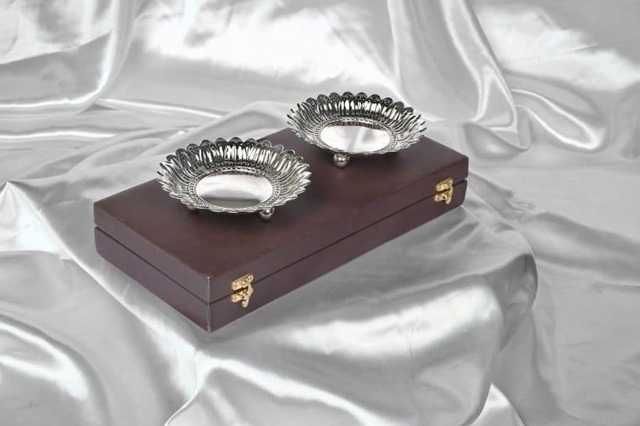 A set of two silver plated sunflower shaped bowls placed over a brown colored rectangular gift box