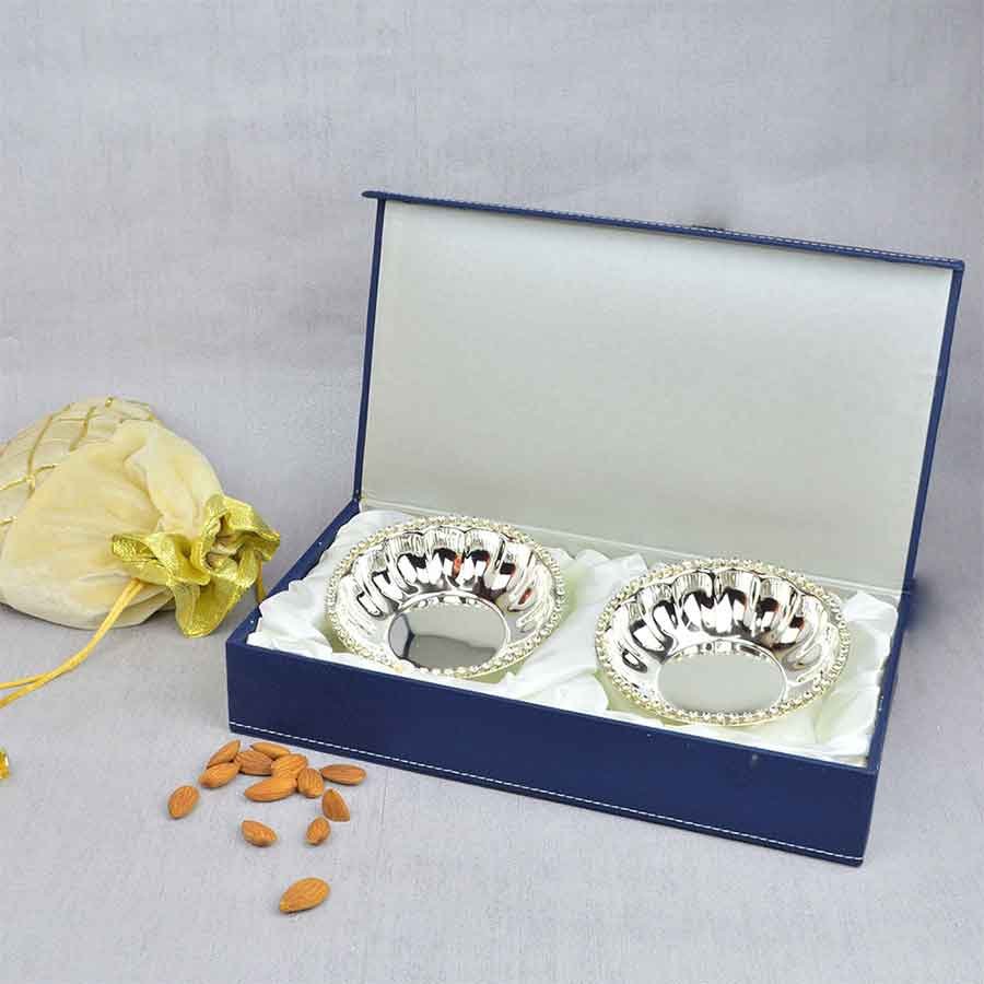 Crystal Rim Fluted Bowl Set appears in the picture resting upon a royal blue gift box.
