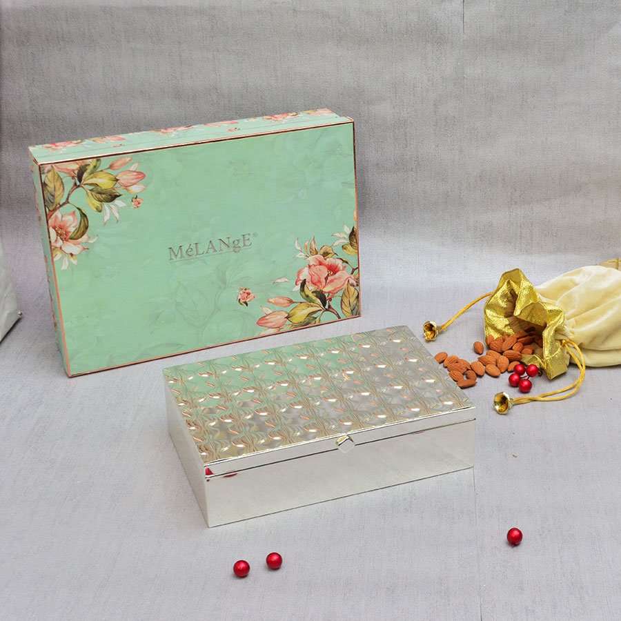 Modish Rectangular Silver Storage Box with an alluring, floral gift box and a bag of almonds laid out on the bright surface.