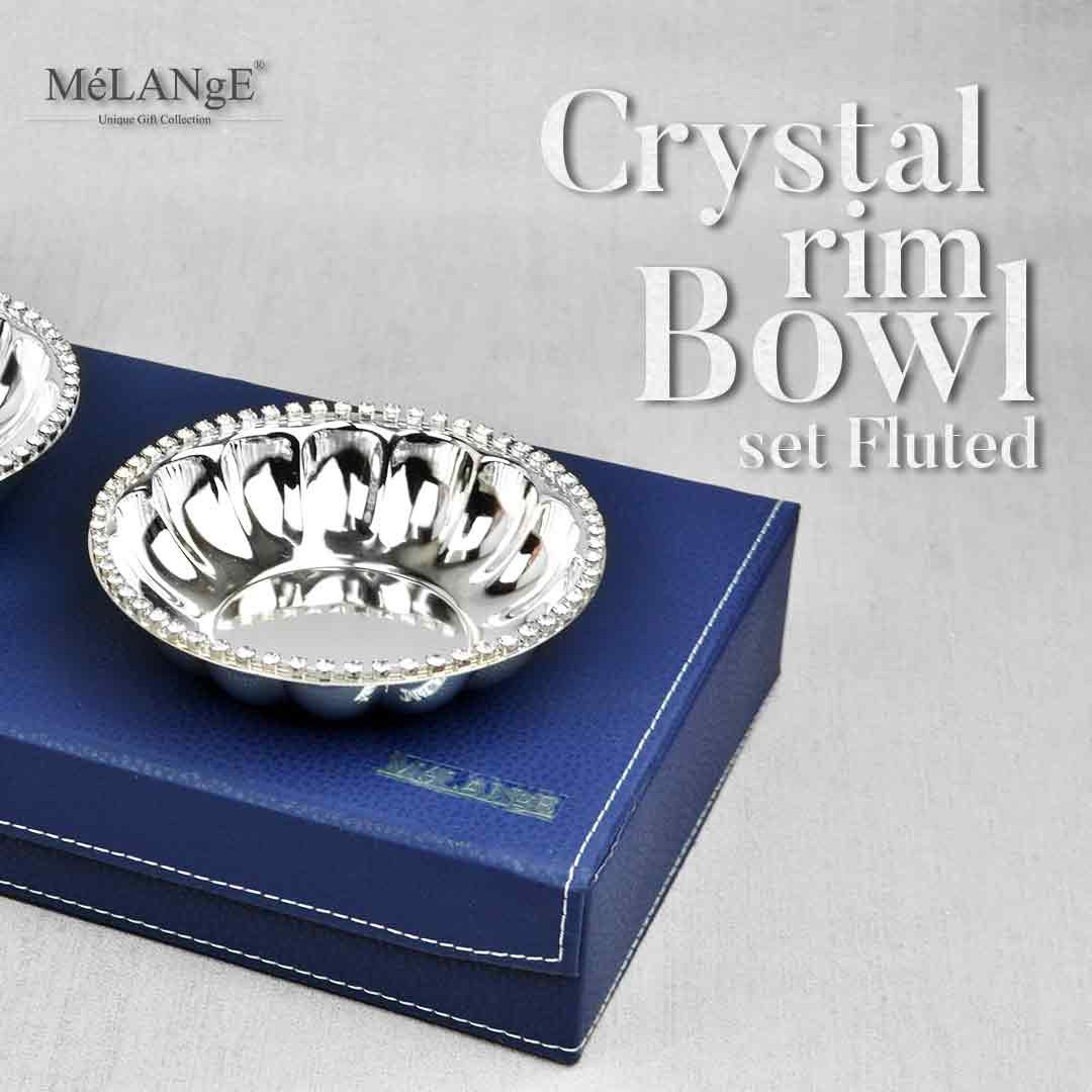 Crystal Rim Fluted Bowl Set appears in the picture resting upon a royal blue gift box.