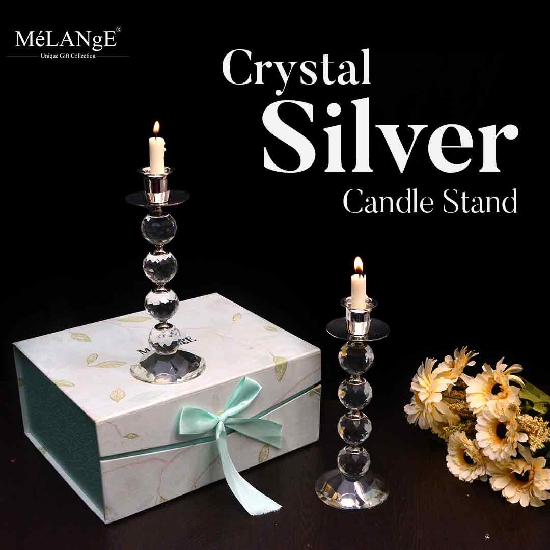 Crystal Silver-plated Candle Stands gleam in the picture with candles in the holders, a gift box and flowers making appearances as well.