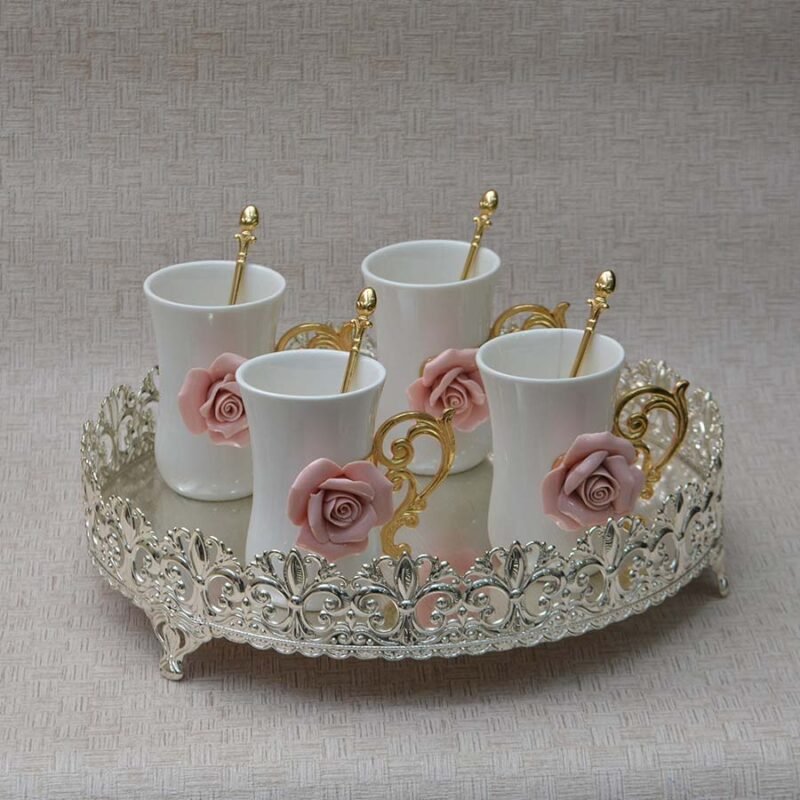 A set of four Ceramic Mugs with embedded roses on a cutwork round thali
