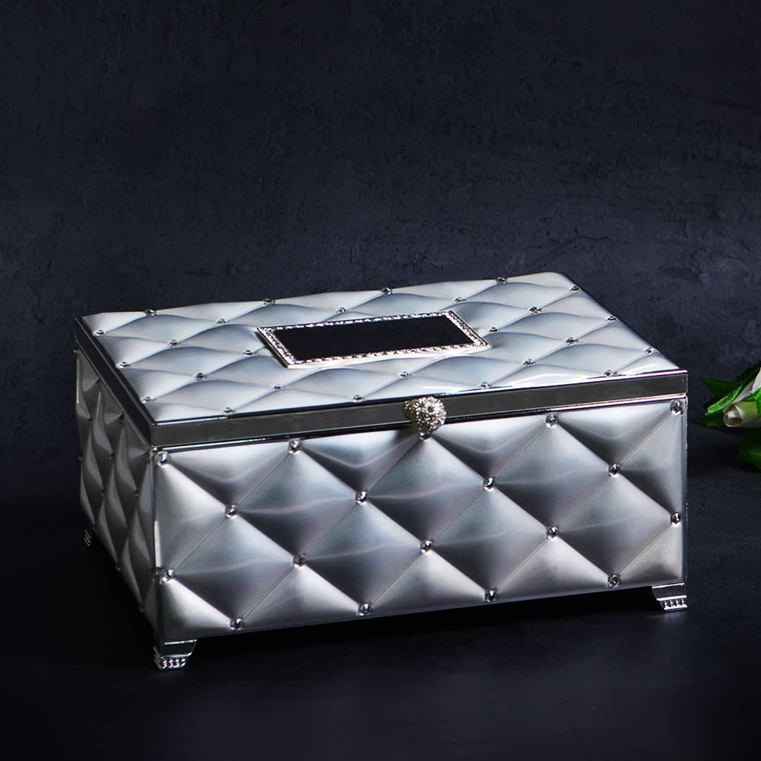 A closed organised box kept against a black background. The premium quality box is in silver-plating & features a tufted design on the surface.